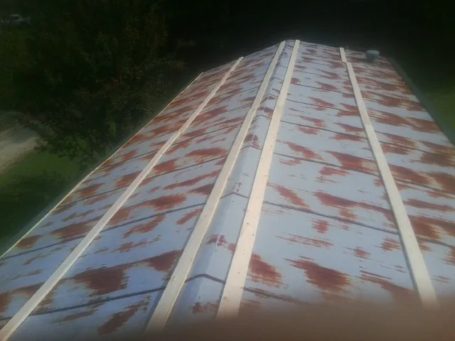 Rusted metal roof panels with new wood purlins before replacement — Storm Damage Roof Repair in Wirtz by Roofing Brothers