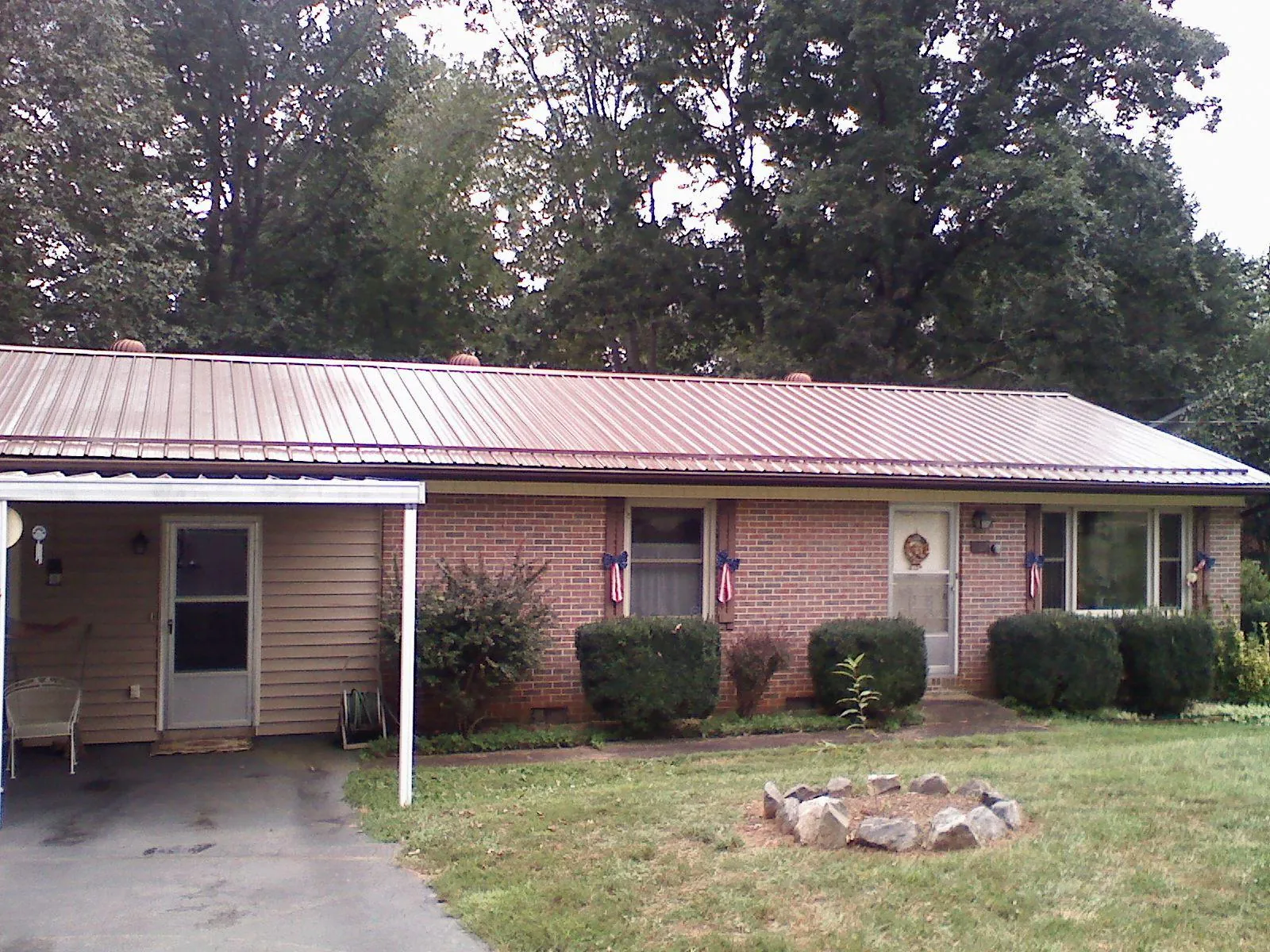 Bronze metal roof and carport on a brick ranch home — Roof Repair work by our crew in Wirtz