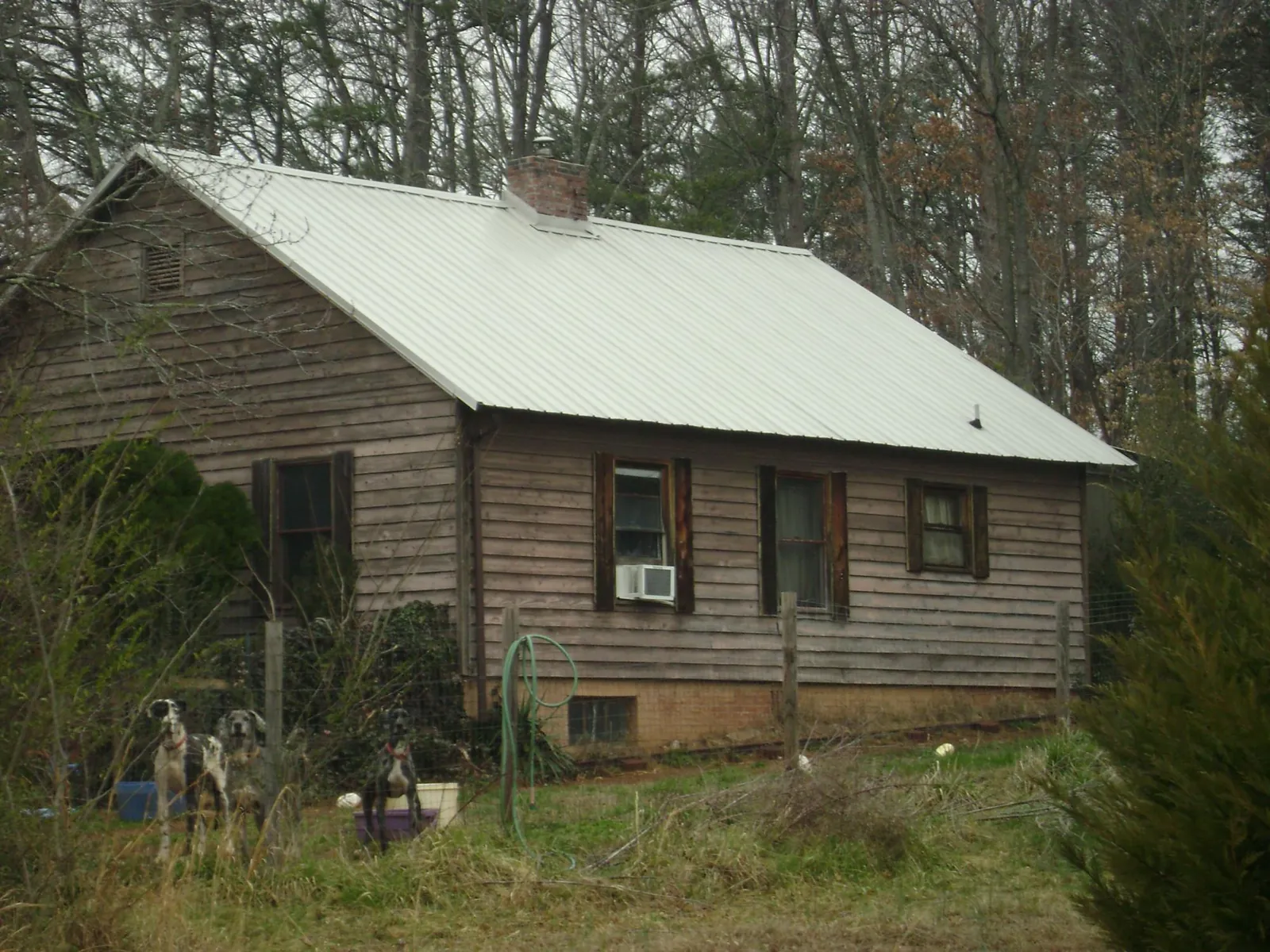 White metal roof on an old wood sided farmhouse, from a Metal Roof Installation job in Wirtz